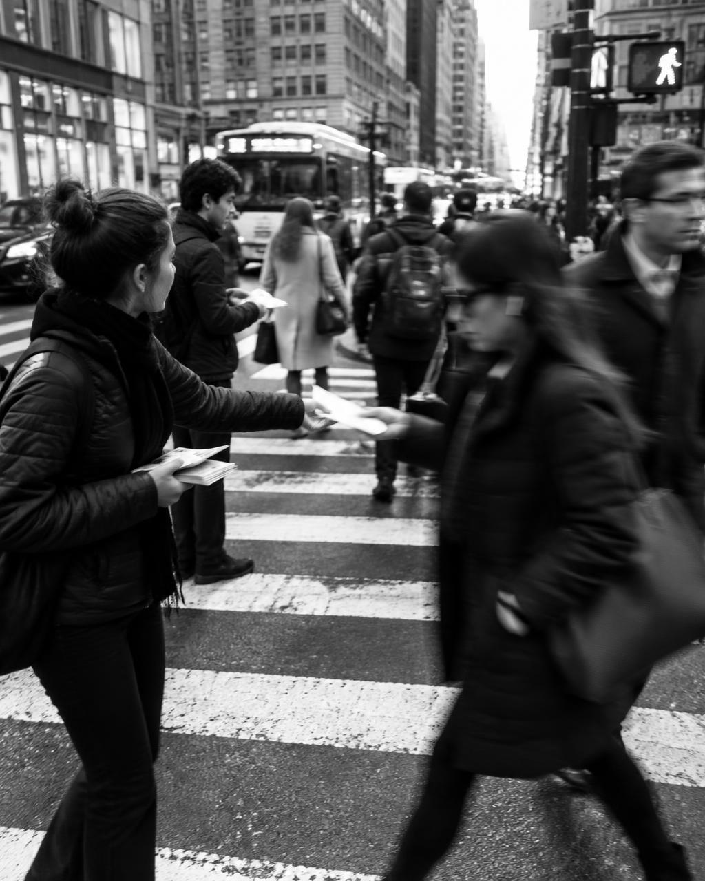 Street team handing flyers to pedestrians on a crosswalk